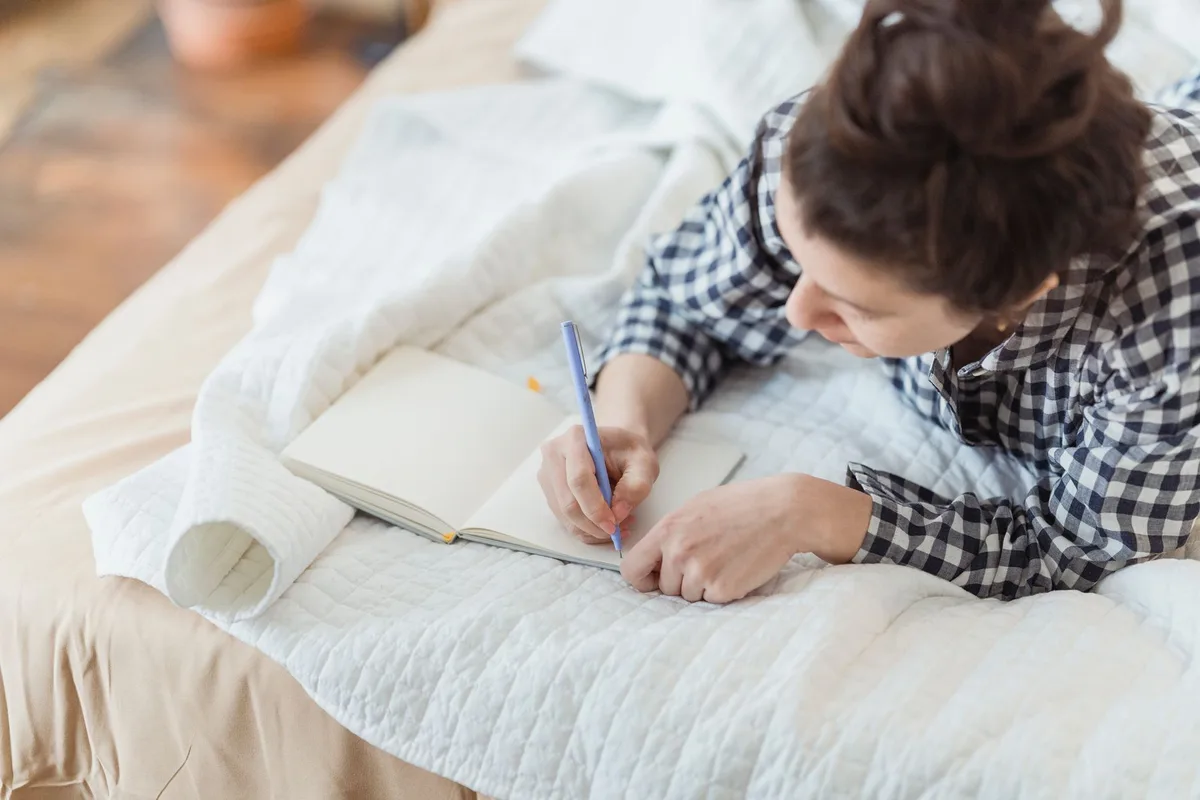 Personne écrivant dans un journal pour pratiquer la gratitude quotidienne