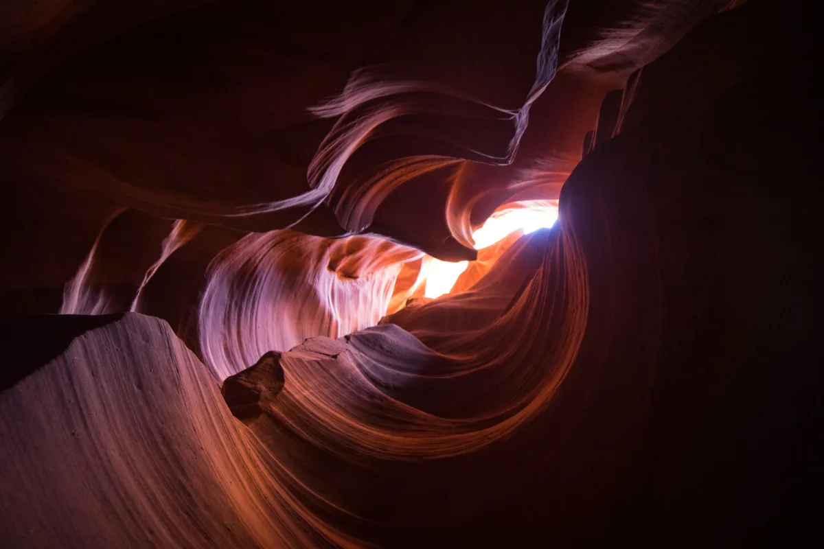 Randonneurs marchant dans un slot canyon aux parois colorées et photogéniques