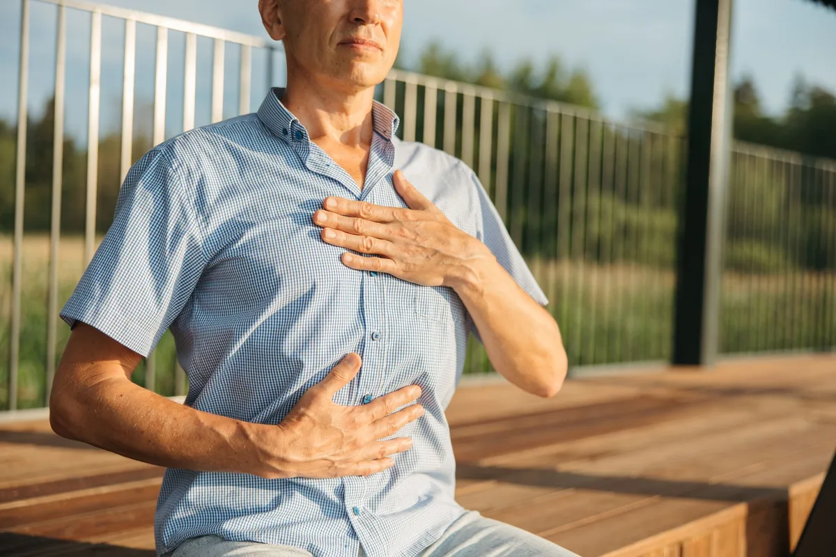 Personne en position de détente, respirant calmement dans un environnement paisible