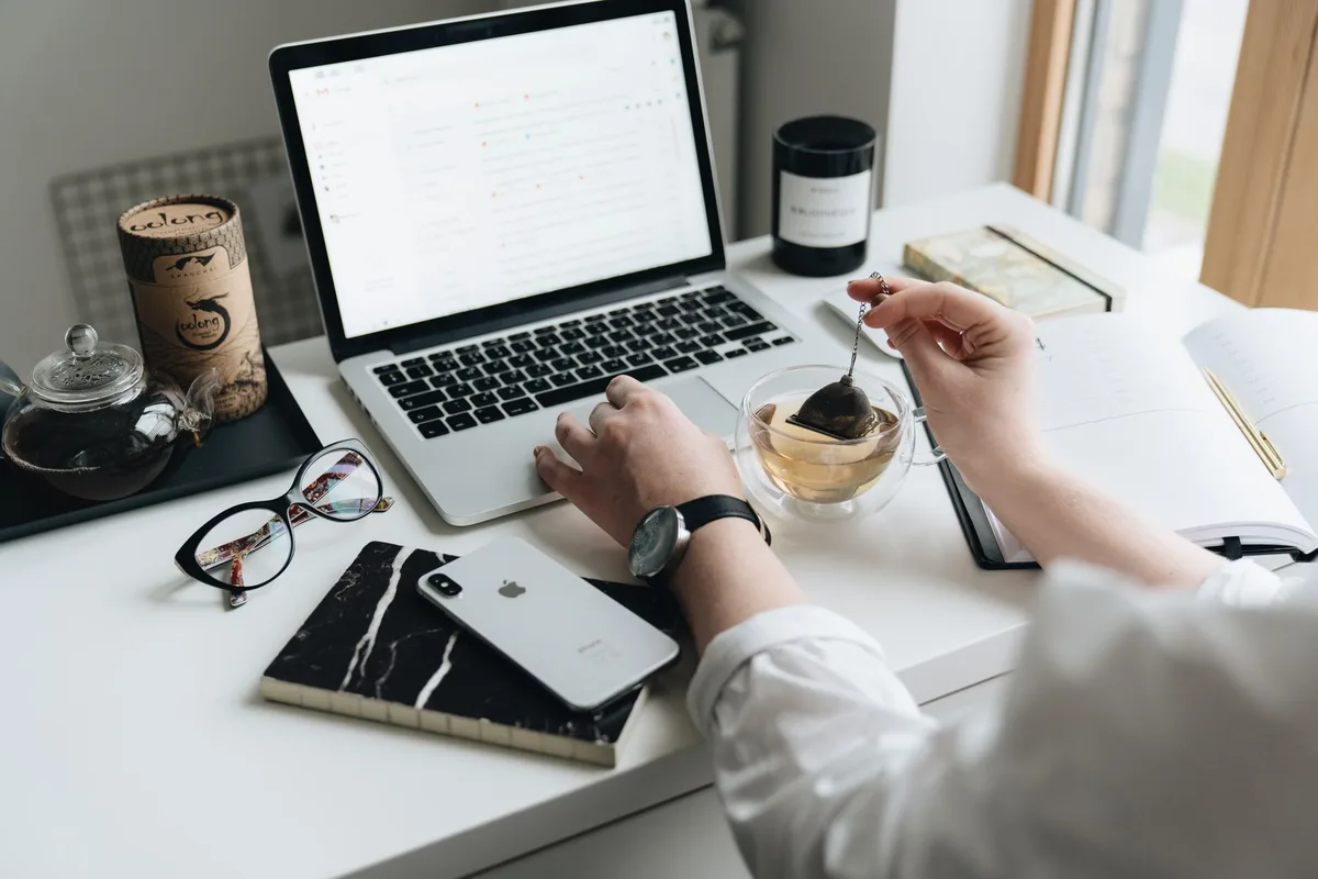 Espace de travail organisé le matin avec une tasse et un carnet de priorités