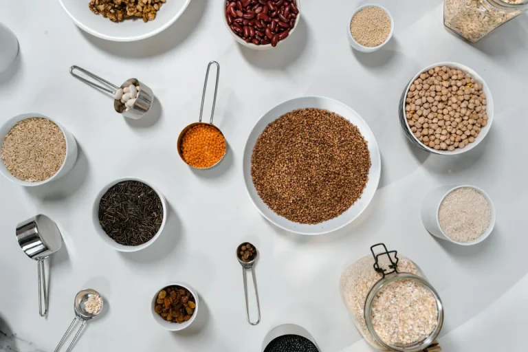 Bocaux de céréales et épices sur un plan de travail de cuisine, lumière naturelle.