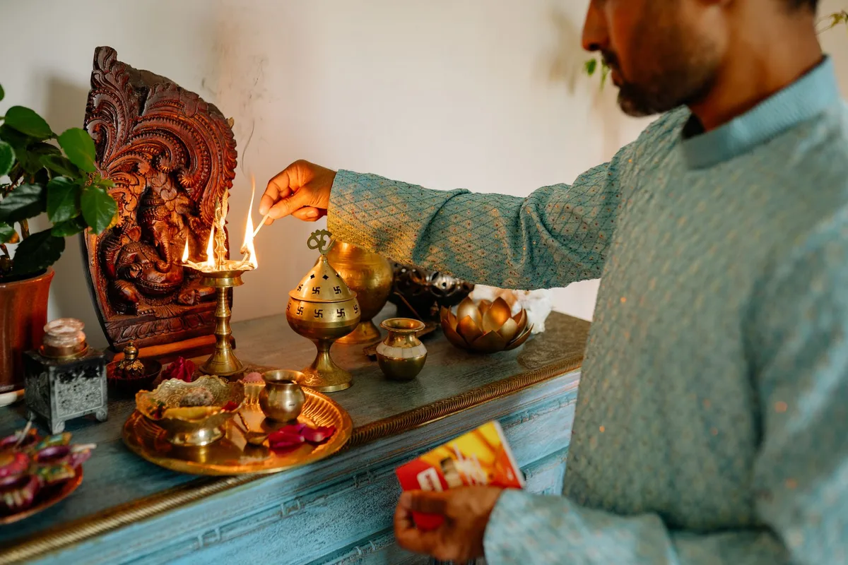 Autel de puja avec lampe allumée, encens et offrandes simples