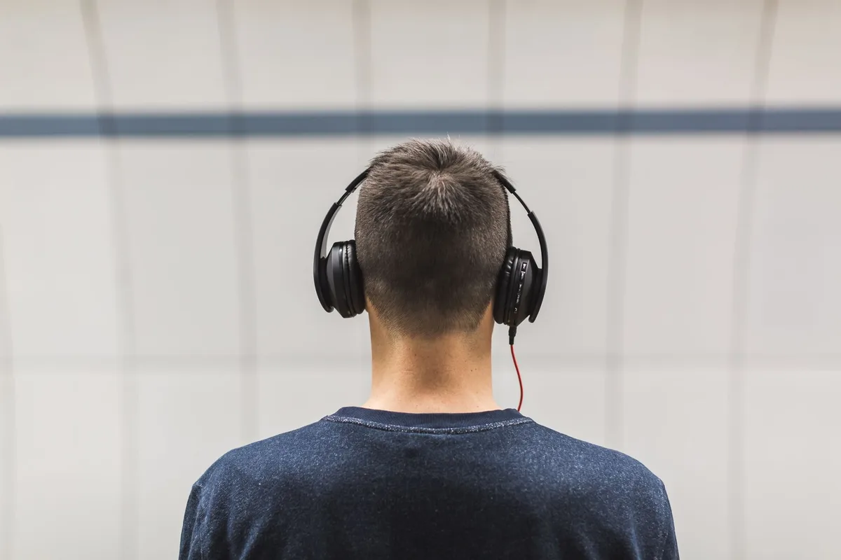 Personne portant un casque écoutant de la musique avec une expression calme et détendue.
