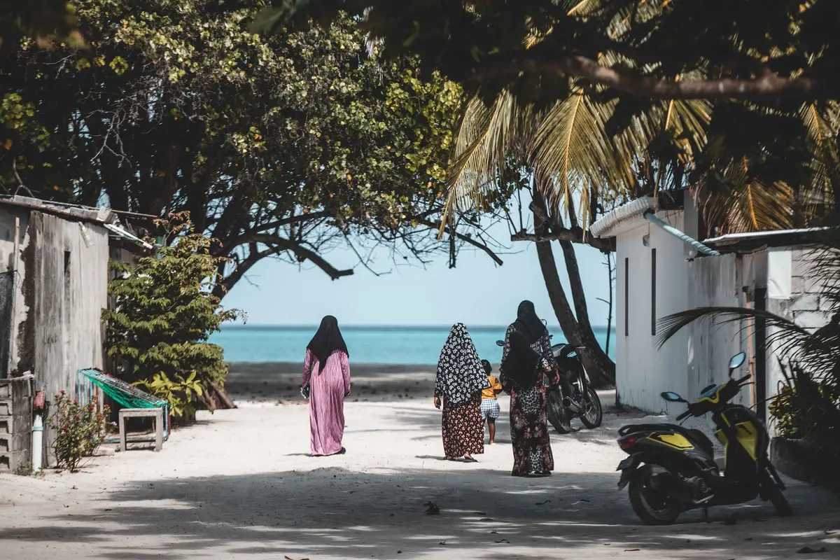 Motocycliste roulant sur une route côtière tropicale avec palmiers