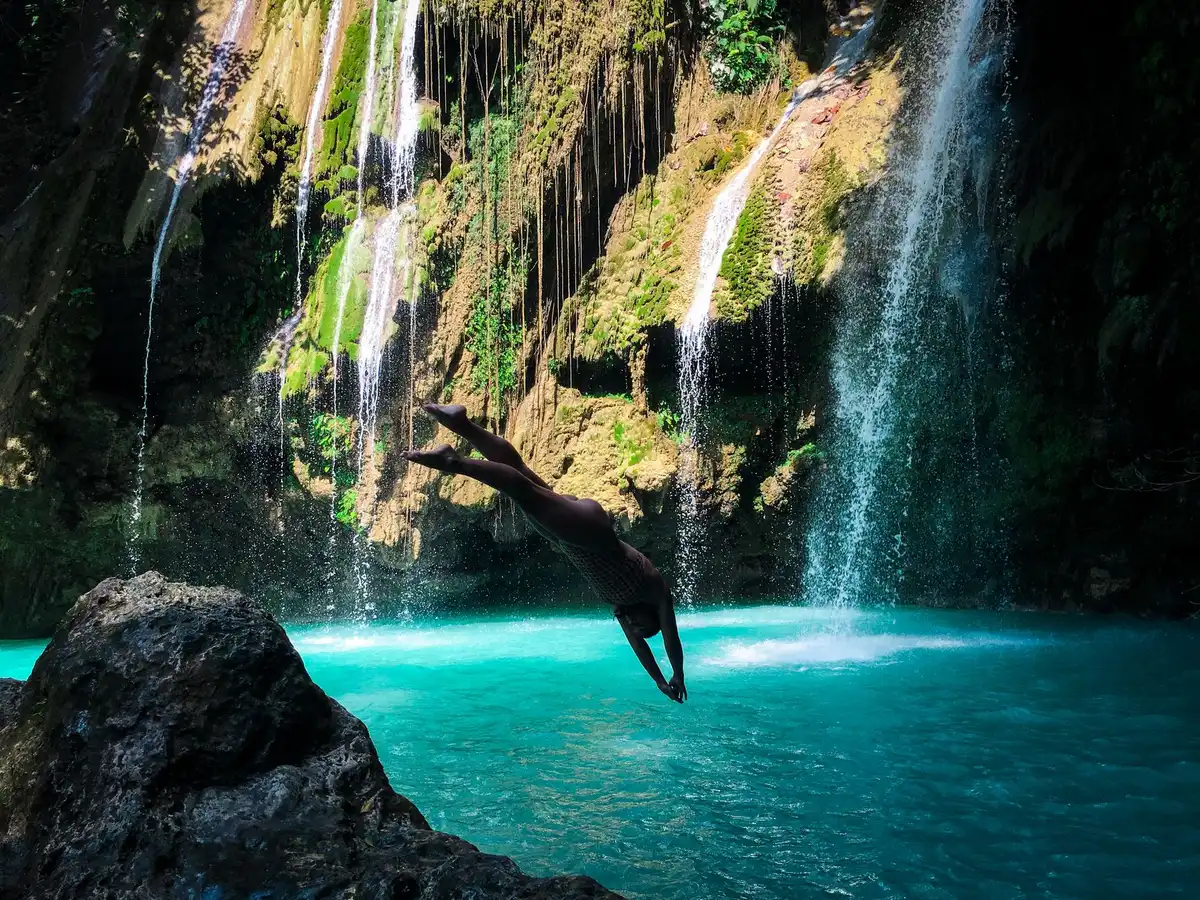 Cascade tropicale avec bassin d'eau turquoise entouré de végétation luxuriante
