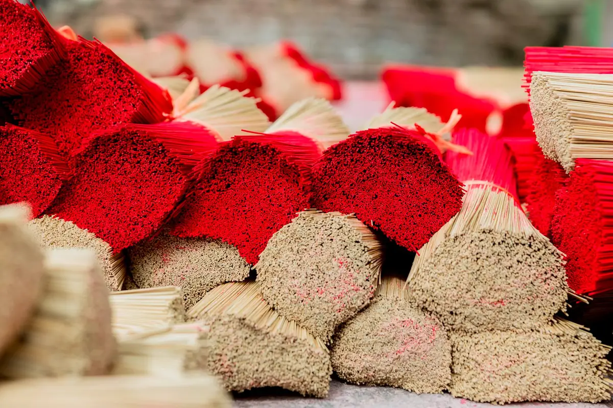 Bâtons d'encens colorés étalés pour sécher dans les cours du village