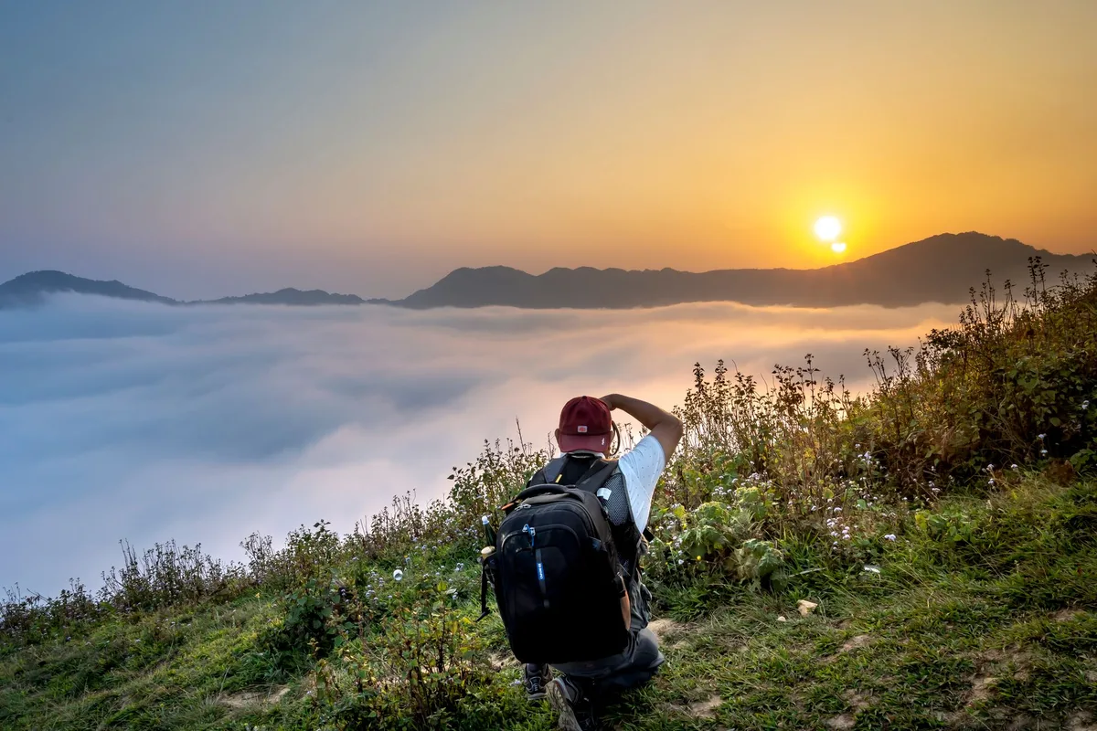 Photographe captant la lumière douce du matin sur un paysage