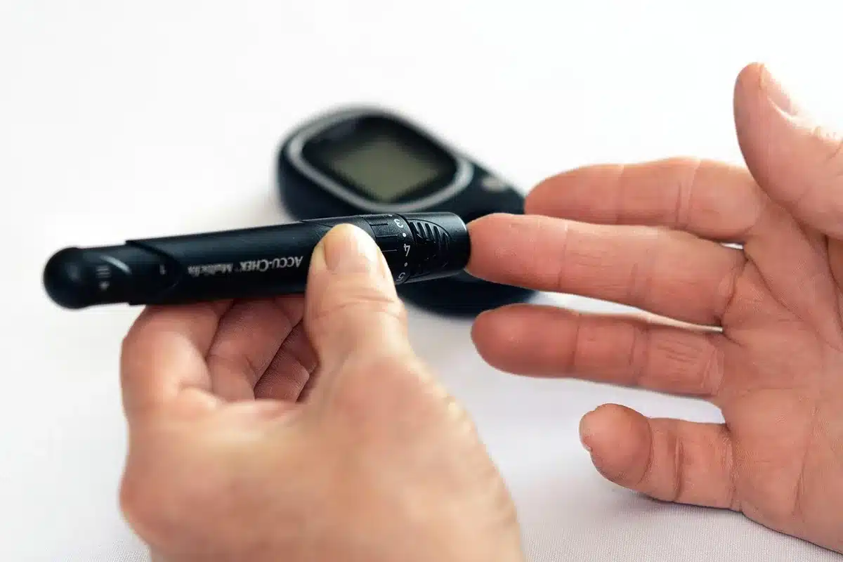 Glucomètre et en-cas riche en glucides sur une table, illustrant études sur la glycémie