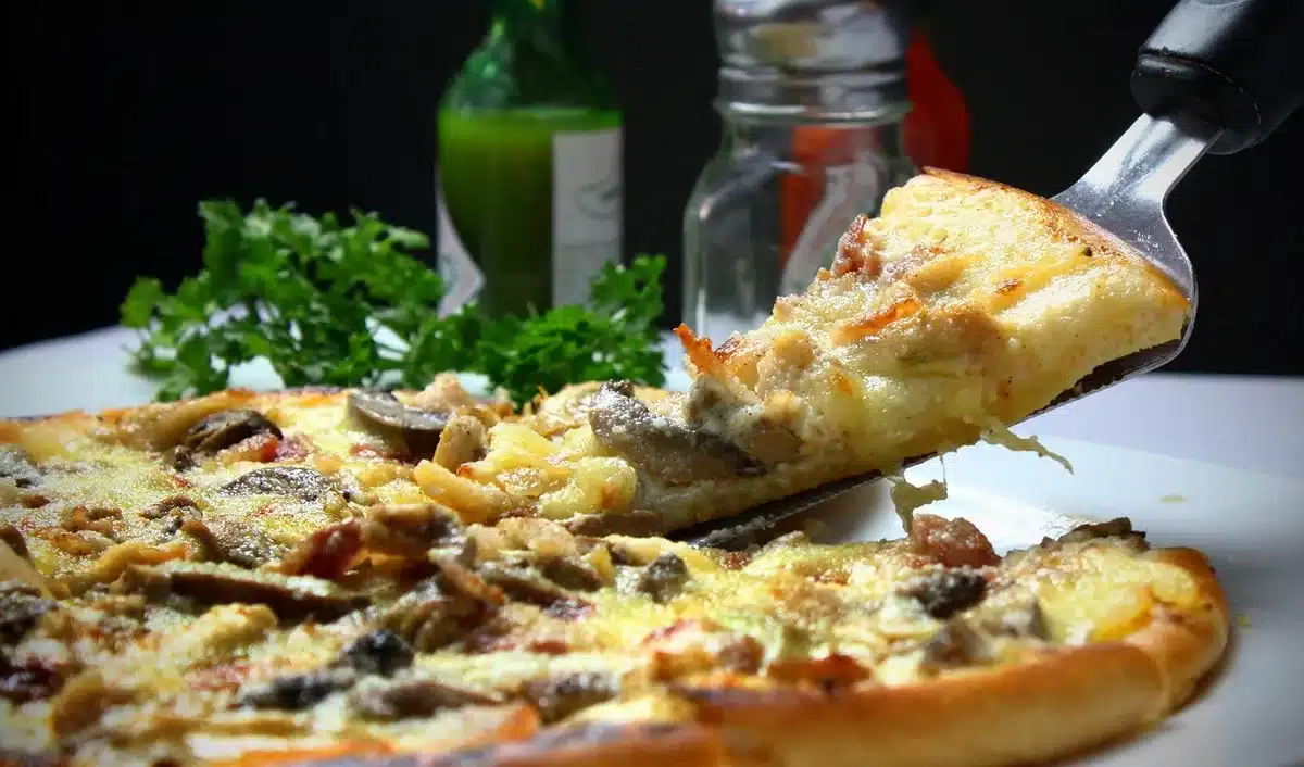 Tranches d'aubergine garnies de fromage râpé sur une plaque de cuisson