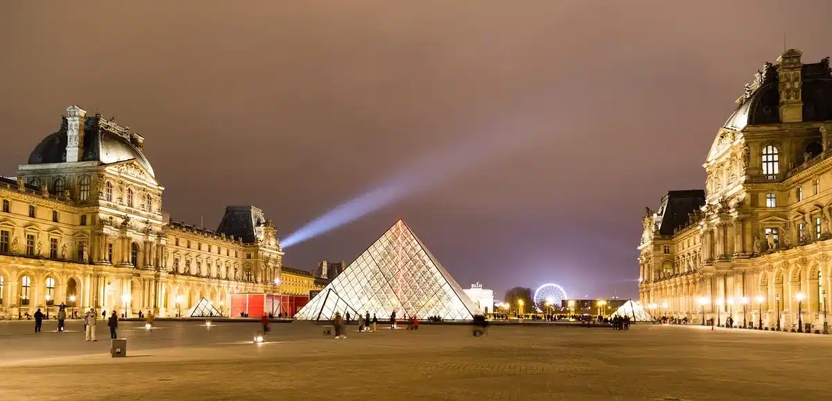 Balade à dos de chameau en journée près des structures de pierre avec visiteurs