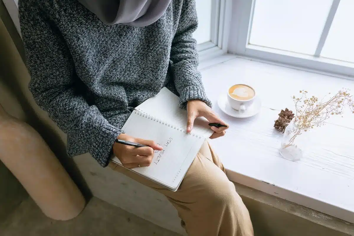 Liste d'intentions écrite à la main sur une feuille près d'un stylo