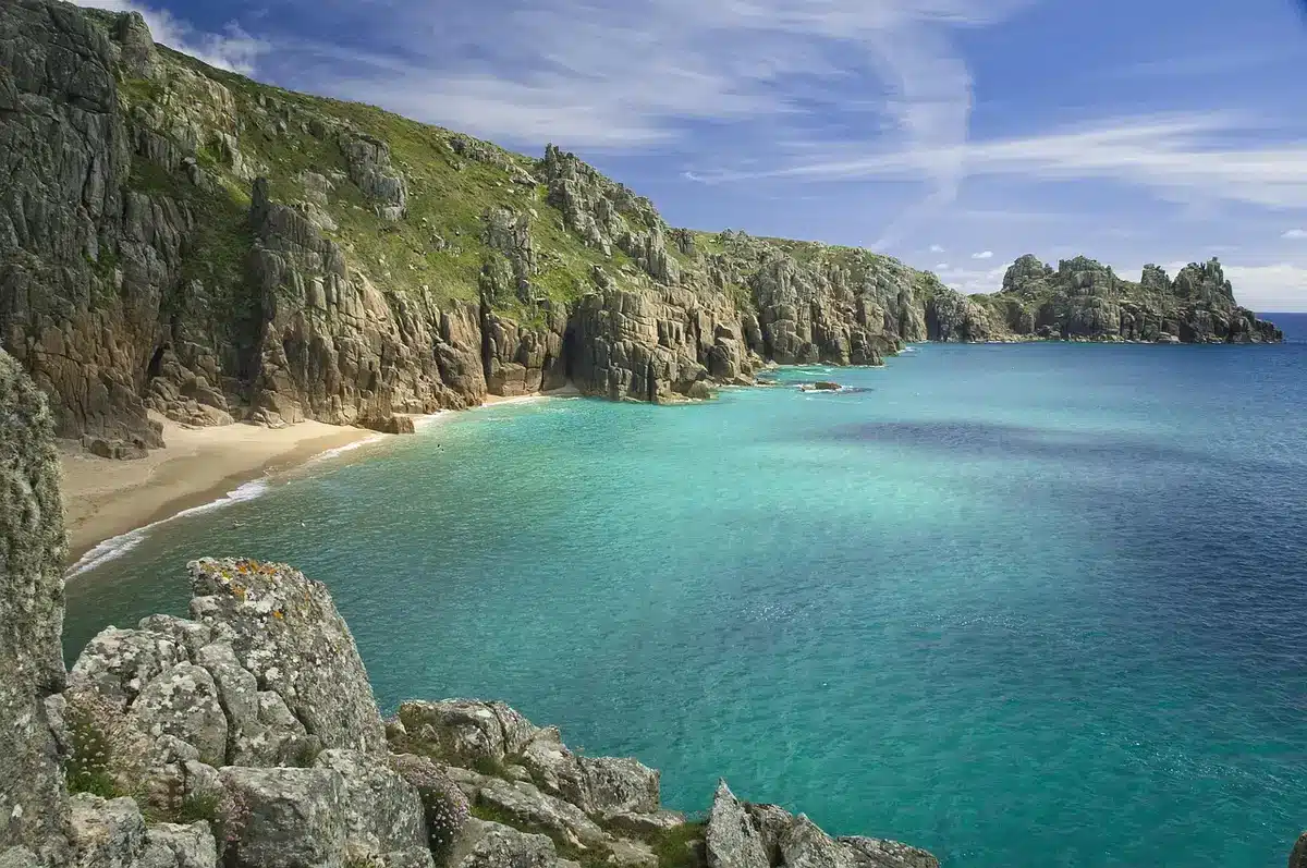 Escaliers descendant depuis une falaise vers une plage de sable blanc
