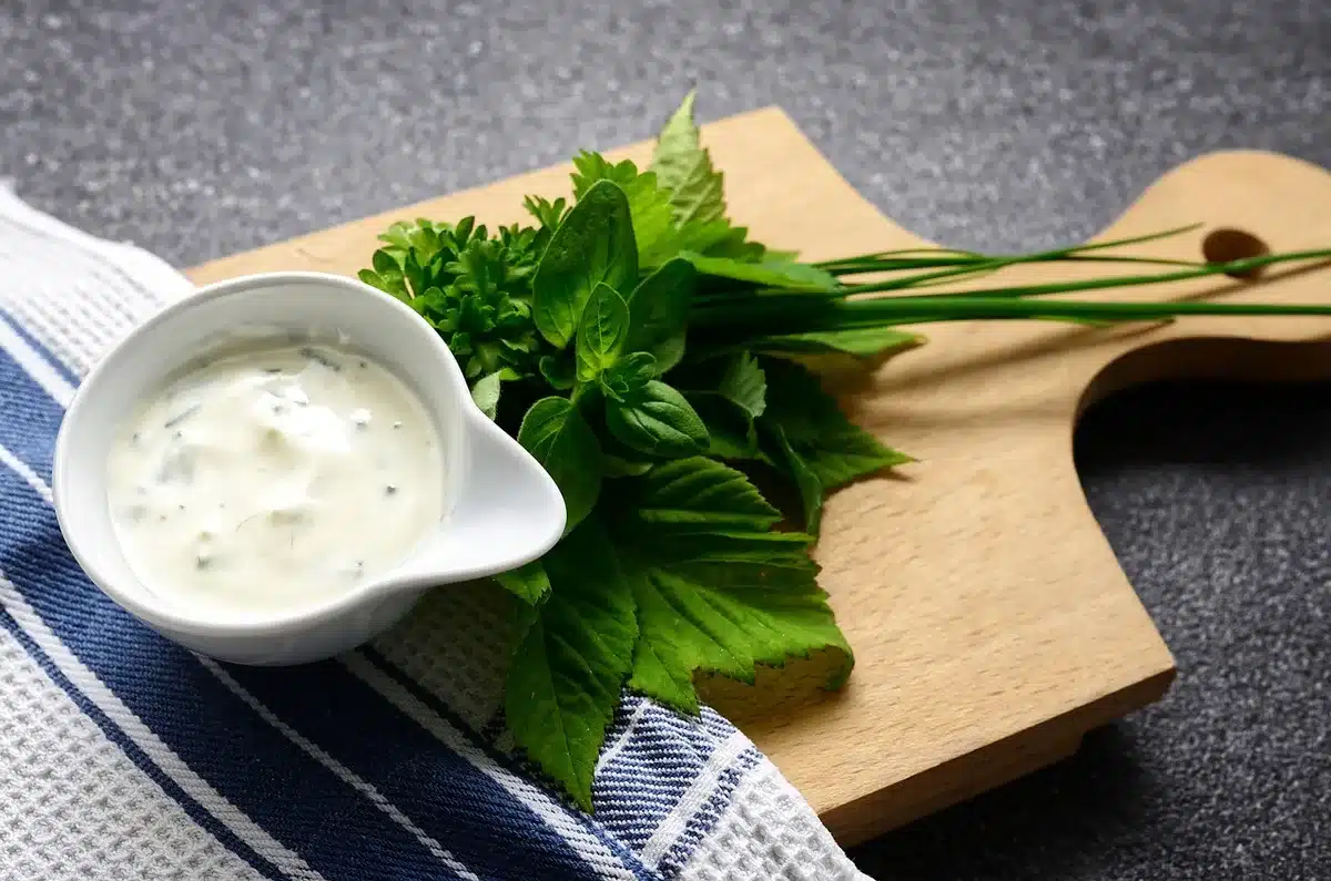 Assortiment d'aromatiques comme la menthe et l'ail sur une planche de cuisine