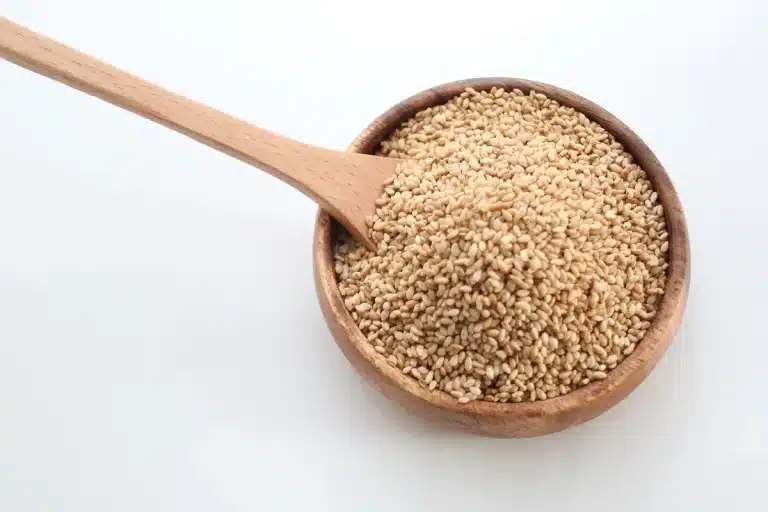 Bol de yaourt et petite coupelle de graines de nigelle sur une table près d'une fenêtre en plein jour