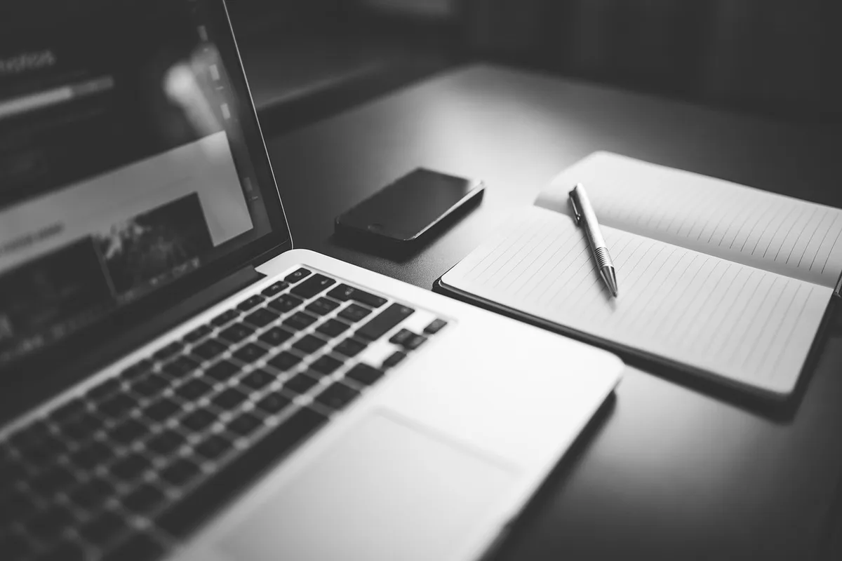 Carnet avec une liste de prompts posée sur une table en journée