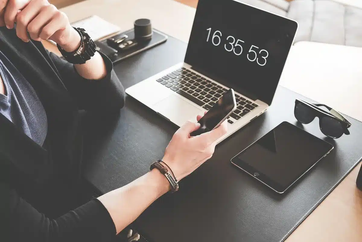 Smartphone posé sur un bureau avec notifications à l'écran, interrompant le travail