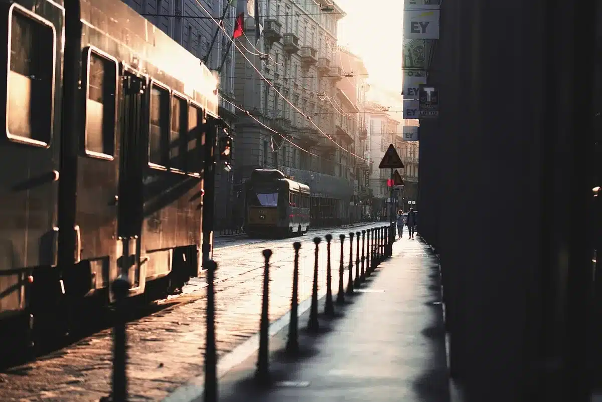 Trottoir urbain couvert de feuilles devant un logement, vue de jour