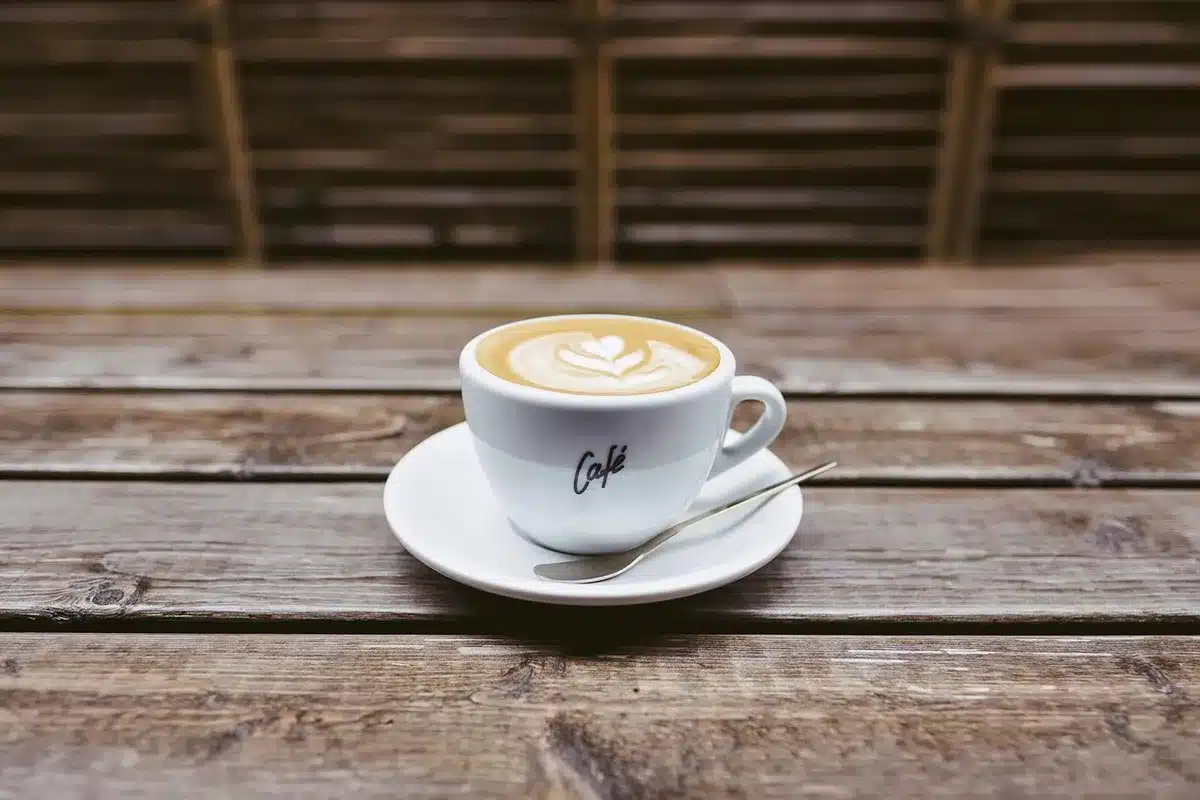 Carnet et tasse de café sur une table au réveil près d'une fenêtre ensoleillée
