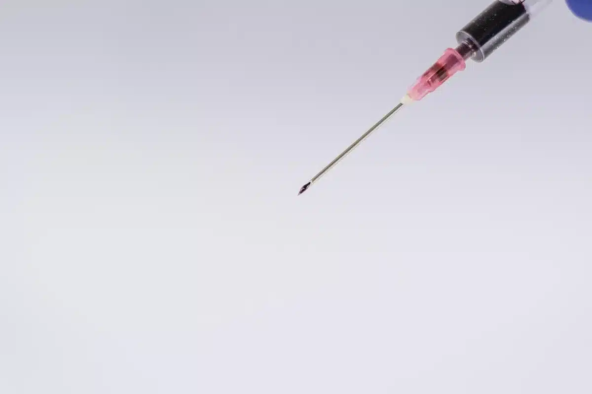 Professionnel de santé tenant une seringue de vaccin dans une salle bien éclairée